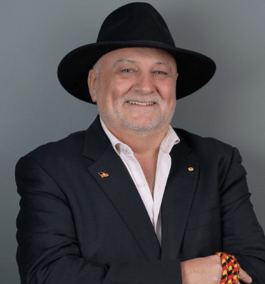 Deen Sanders wearing a black blazer, white shirt and black hat.