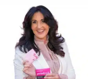 Woman wearing a white blazer and has dark brown hair and is holding a period pack